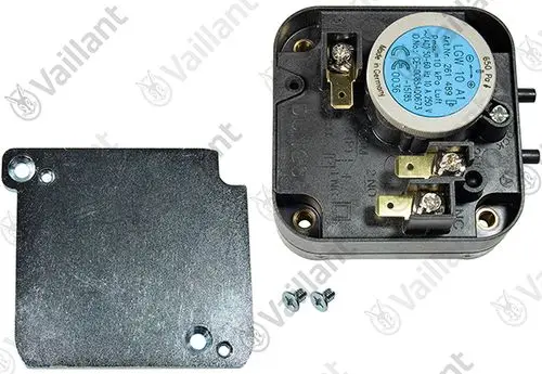 Vaillant Druckwächter mit elektrischen Anschlüssen, montiert auf einem schwarzen Gehäuse, daneben eine Abdeckplatte und Schrauben zur Befestigung.